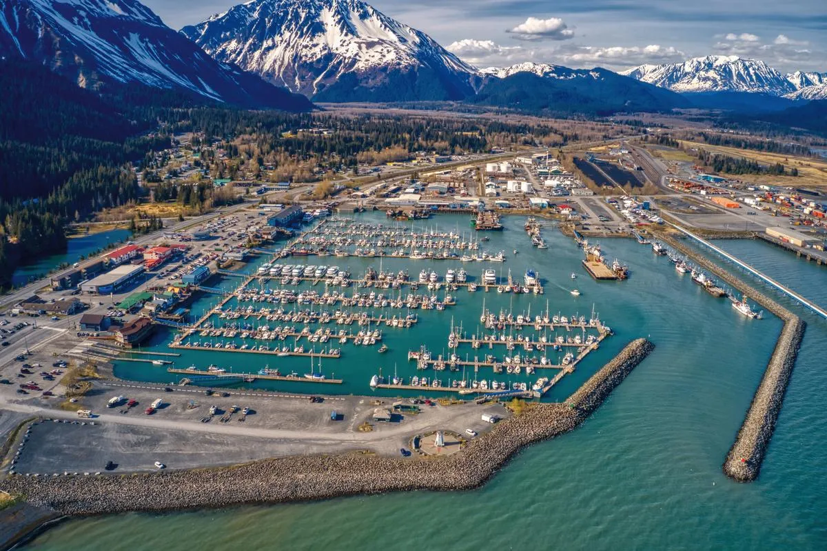 An aerial view of Seward's small boat harbour, the moored fleet and the mountains behind it
